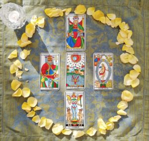 5 cartes de Tarot entourées de pétales de rose